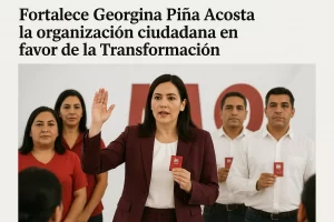 Georgina Piña Acosta levantando la mano y sosteniendo una tarjeta, acompañada de cuatro personas más