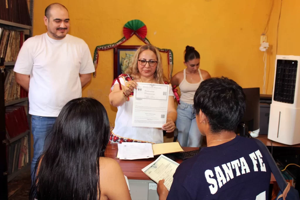 Mujer entregando documento oficial a dos personas en una oficina con pared amarilla