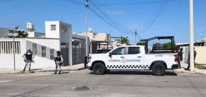 Pick up blanco de la Guardia Nacional con tres agentes de uniforme y chaleco antibalas en una esquina de calle residencial ba