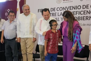 Personas en evento de firma de convenio entre Secretaría de Salud y Gobierno, con banner de fondo