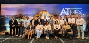 Personas posando en evento ATMEX con fondo del Palacio de Bellas Artes