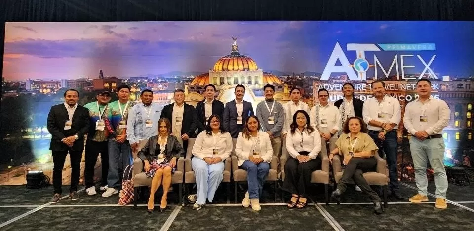 Personas posando en evento ATMEX con fondo del Palacio de Bellas Artes
