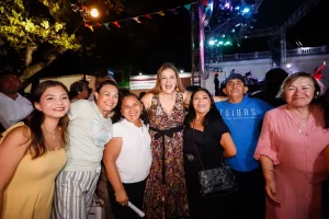 Siete personas sonrientes en evento nocturno con luces de escenario y decoraciones coloridas