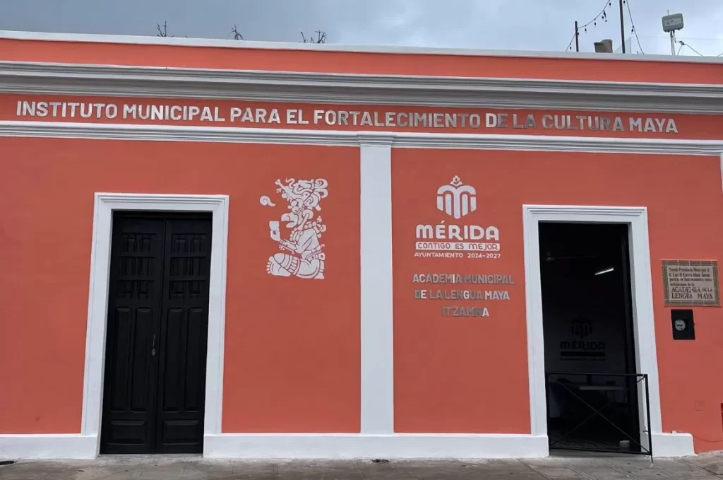 Fachada color naranja de edificio con cartel del Instituto Municipal para el Fortalecimiento de la Cultura Maya en Mérida