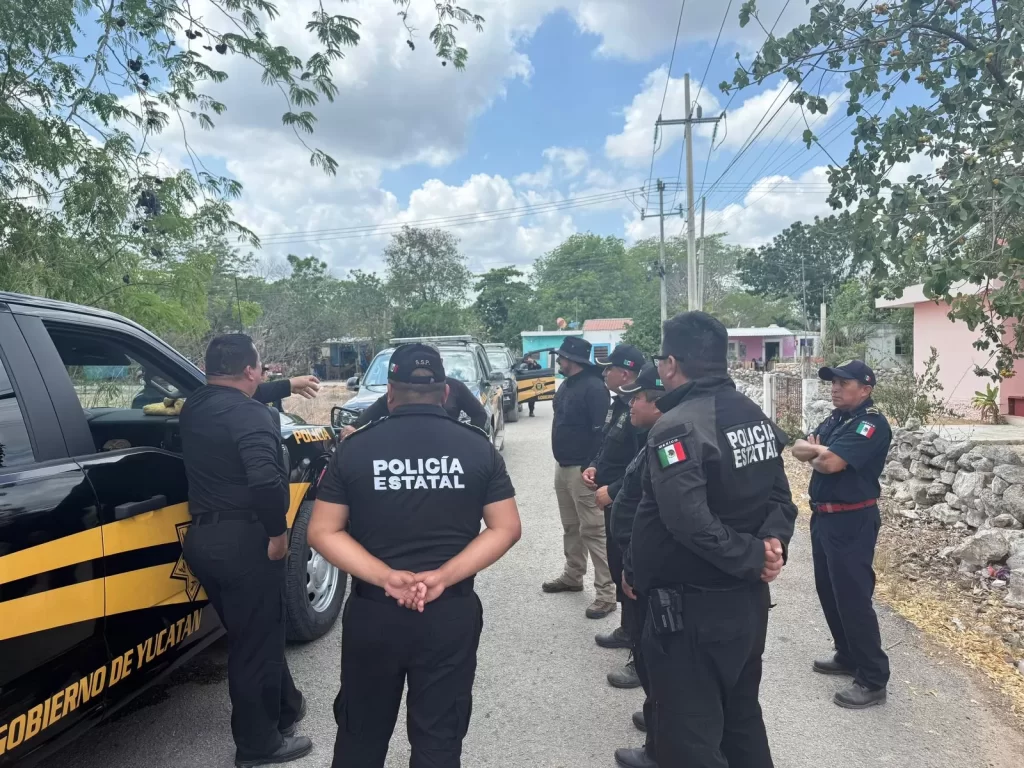Grupo de policías estatales de Yucatán reunidos junto a patrullas en una calle rural durante un operativo
