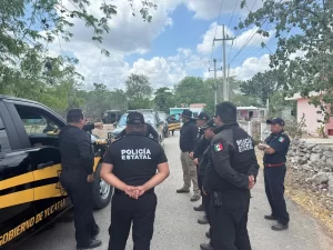 Grupo de policías estatales de Yucatán reunidos junto a patrullas en una calle rural durante un operativo