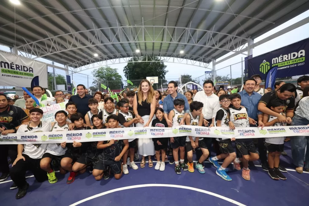 Grupo de niños y adultos en la inauguración de una cancha deportiva techada en Mérida, cortan la cinta oficial