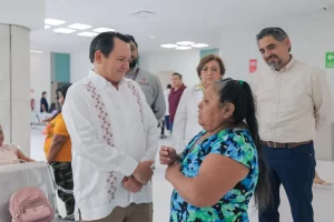 Hombre con guayabera blanca conversando con mujer de blusa azul con estampado