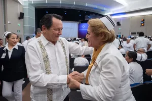 Hombre con camisa típica saludando alegremente a enfermera con uniforme blanco en auditorio