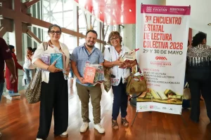 Tres personas sonrientes sosteniendo libros en el 3er Encuentro Estatal de Lectura Colectiva 2026 en Yucatán