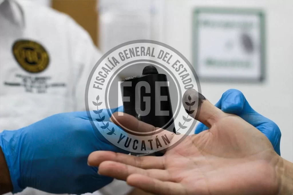Mano con tinta negra en dedo pulgar siendo entintada para toma de huellas digitales