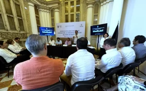 Personas sentadas en un recinto histórico participando en la apertura de talleres para la revitalización del Paseo de Montejo