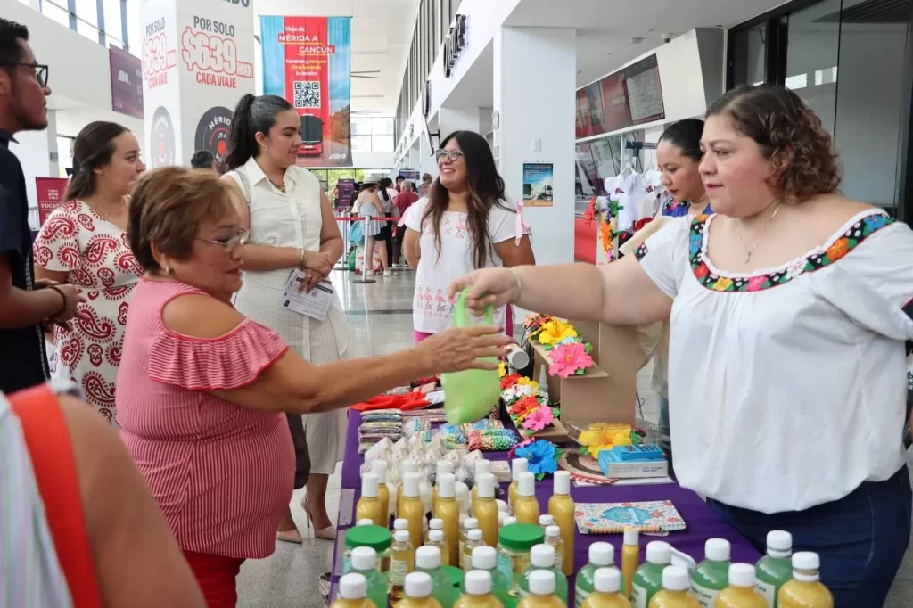 Mujeres en puesto de productos artesanales intercambiando bolsa verde
