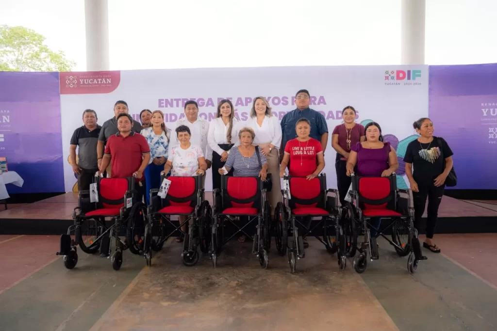 Grupo de personas con discapacidades recibiendo sillas de ruedas en evento oficial en Yucatán
