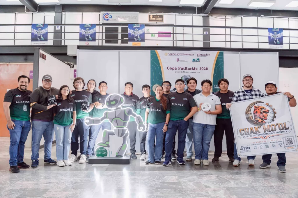 Grupo de jóvenes con camisetas negras y verdes del club Chak Mo'ol en evento Copa FutBotMx 2026, con bandera y robot de exhib