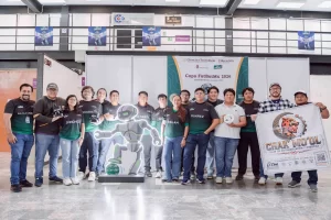 Grupo de jóvenes con camisetas negras y verdes del club Chak Mo'ol en evento Copa FutBotMx 2026, con bandera y robot de exhib