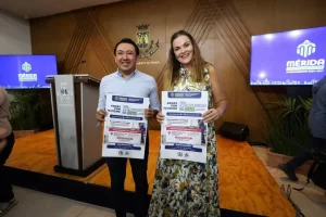 Dos personas sostienen carteles del programa de impermeabilización de techos de Mérida