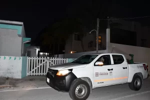 Camioneta blanca de Servicios de Salud de Yucatán circulando en calle residencial de noche