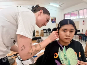 Especialista realizando prueba auditiva a una joven en un centro de salud