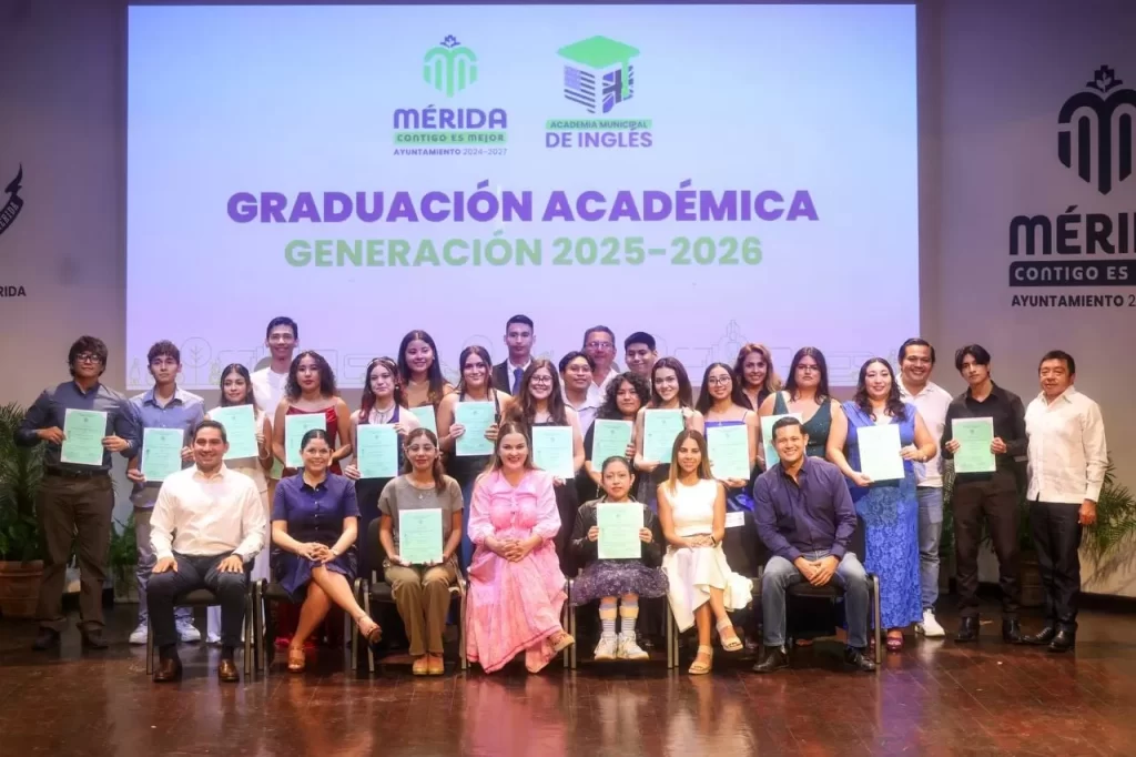 Grupo de graduados y autoridades con certificados en ceremonia de graduación de la Academia Municipal de Inglés en Mérida