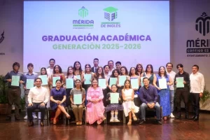 Grupo de graduados y autoridades con certificados en ceremonia de graduación de la Academia Municipal de Inglés en Mérida