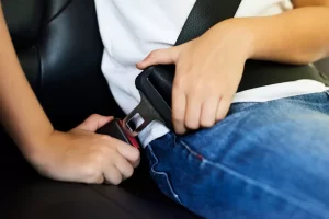 Manos abrochando el cinturón de seguridad en un automóvil